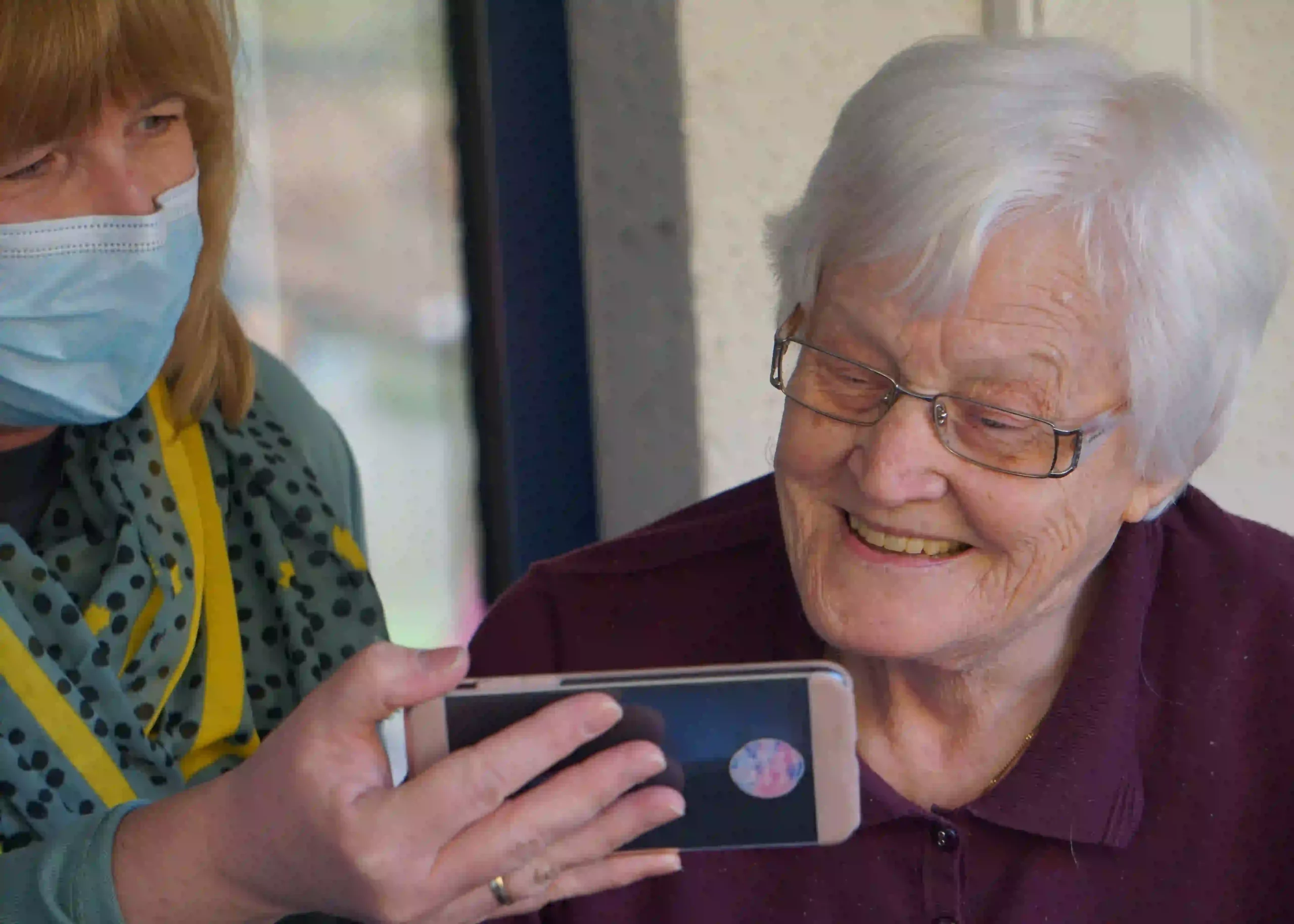 Elderly woman looks at phone